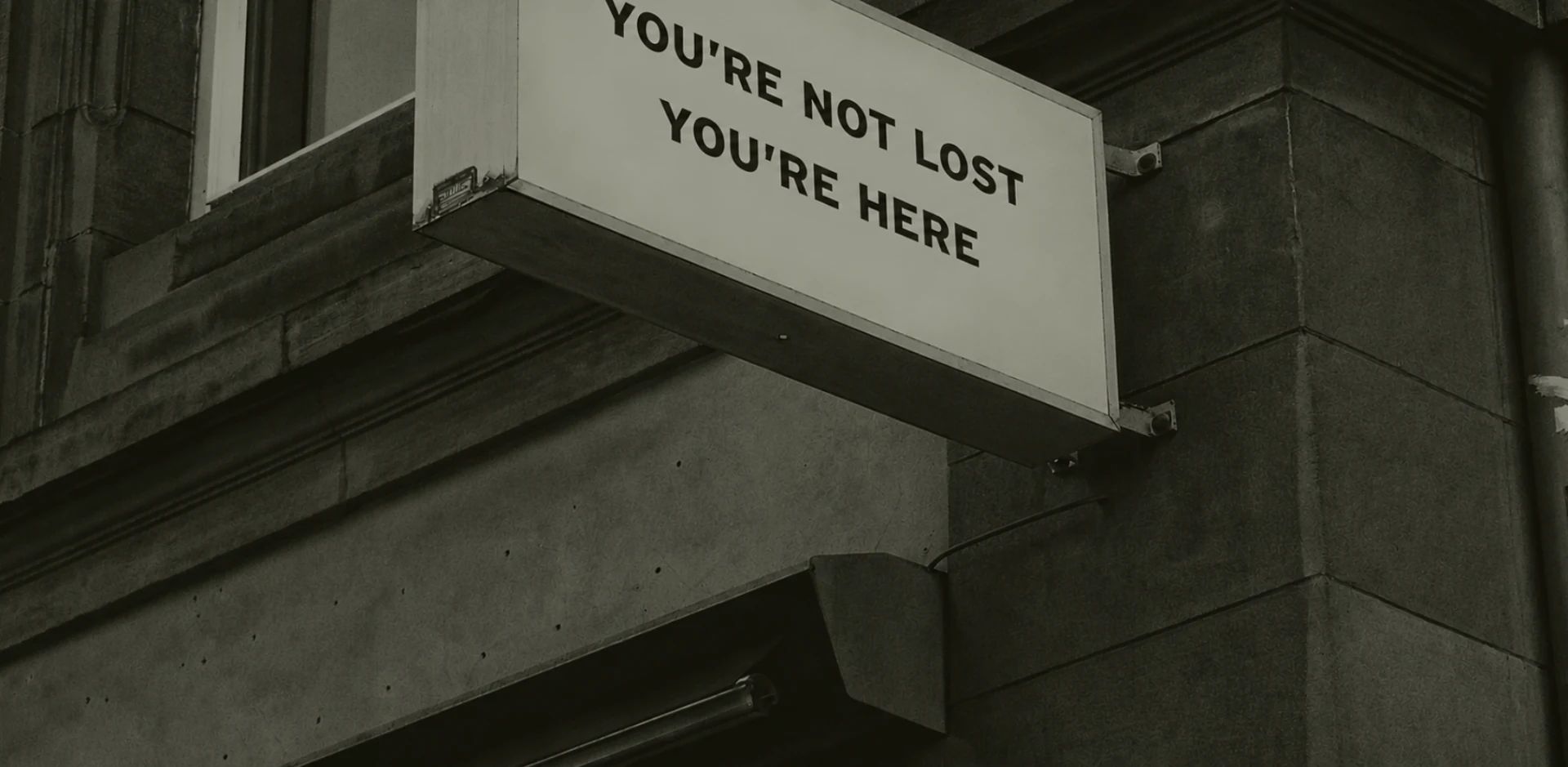A building sign reading You're not lost, you're here